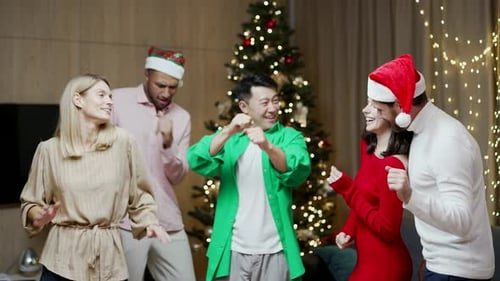 Friends dancing in front of the tree.