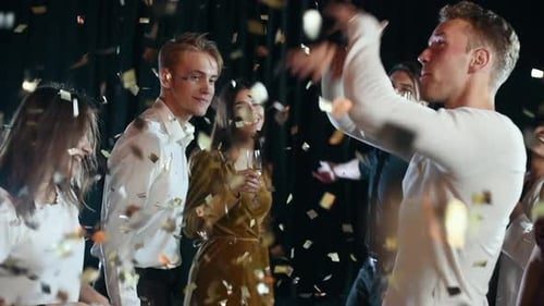 The whole party dancing as confetti falls.