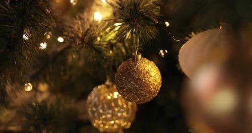 The camera glides past gold ornaments on the lit tree.