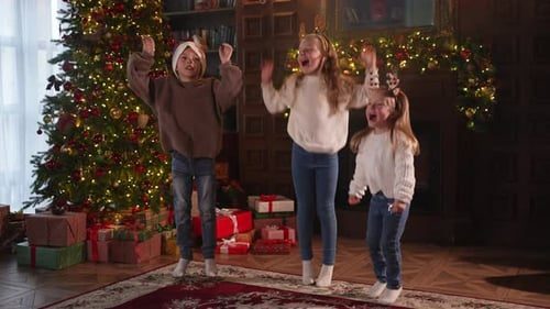 Kids jumping and cheering by the tree.