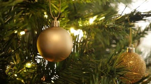 Gold ornament and warm lights, close.