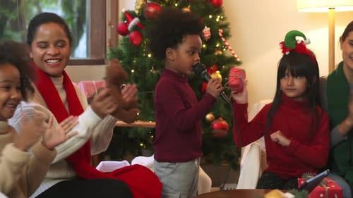 Kids singing into the microphone, mom clapping.