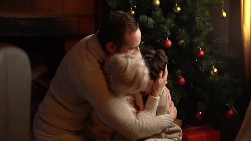 A family hug by the tree.