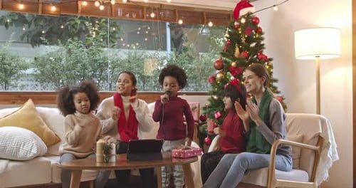 The family singing carols on the sofa.