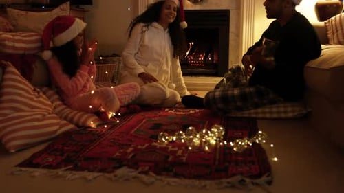 The family sings carols by the fireplace.